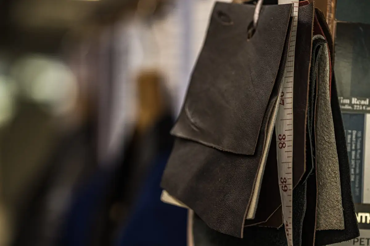 Bundle of coat and cashmere swatches hanging with a tape measure at the 38 inch mark