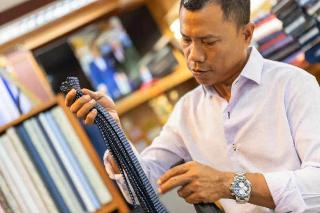 Johnny choosing a tie from the rail in the shop