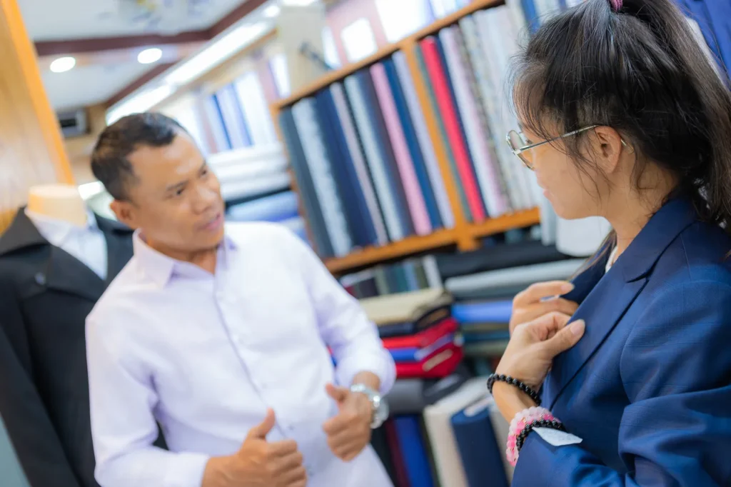 Johnny adjusting the fit of a blue jacket on a customer